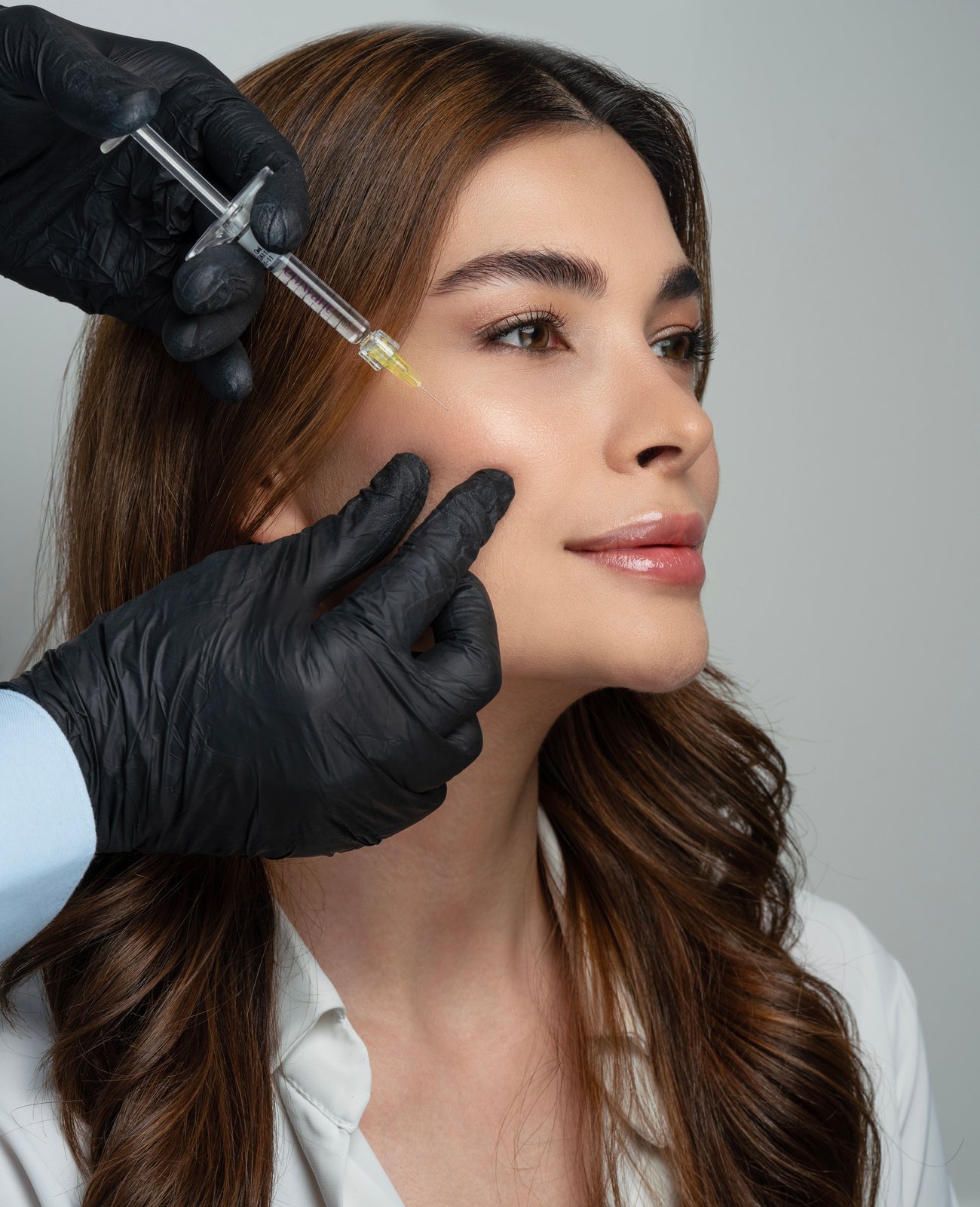 Arab dermatologist performing a skin procedure at Muscat Dermatology